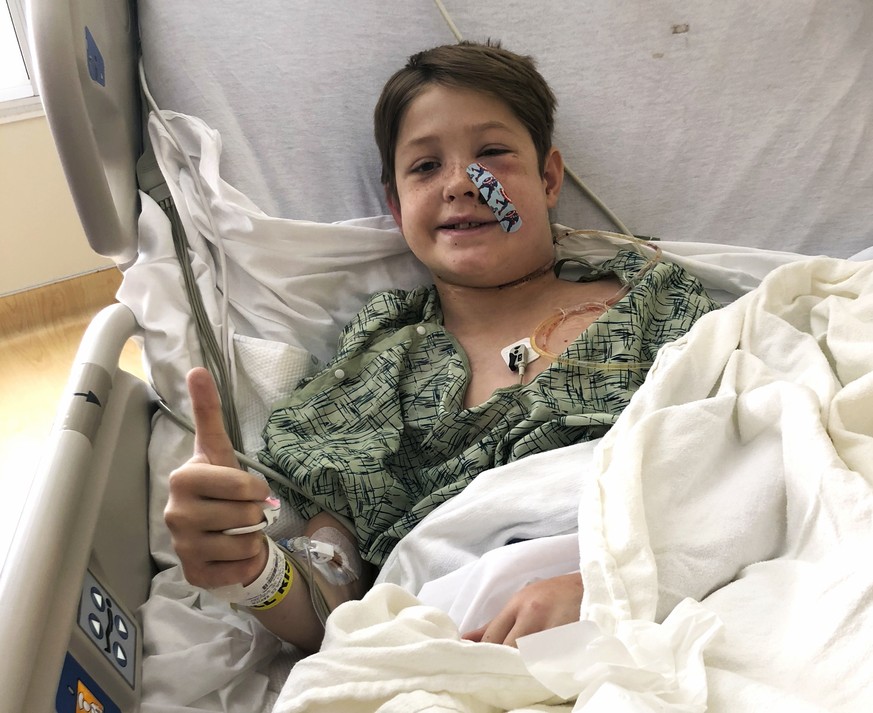 In this Monday, Sept. 10, 2018 photo provided by Shannon Miller, his son Xavier Cunningham, of Harrisonville, Mo., gives a thumbs up while recovering at the University of Kansas Hospital in Kansas Cit ...