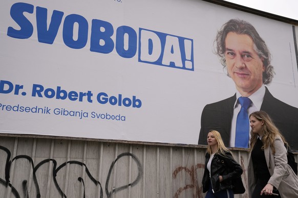 Pedestrians walk past electoral poster of Robert Golob, a liberal candidate, in Ljubljana, Slovenia, Thursday, April 21, 2022. The vote on Sunday April 24 in Slovenia will be held amid heightened poli ...