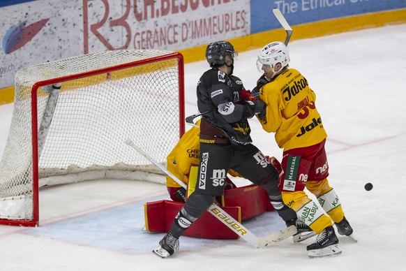 Matthew Verboon (GSHC), centre, lutte pour le puck avec Juuso Riikola (SCL), droite, devant le gardien Robin Meyer (SCL), gauche, lors du match du championnat suisse de hockey sur glace de National Le ...