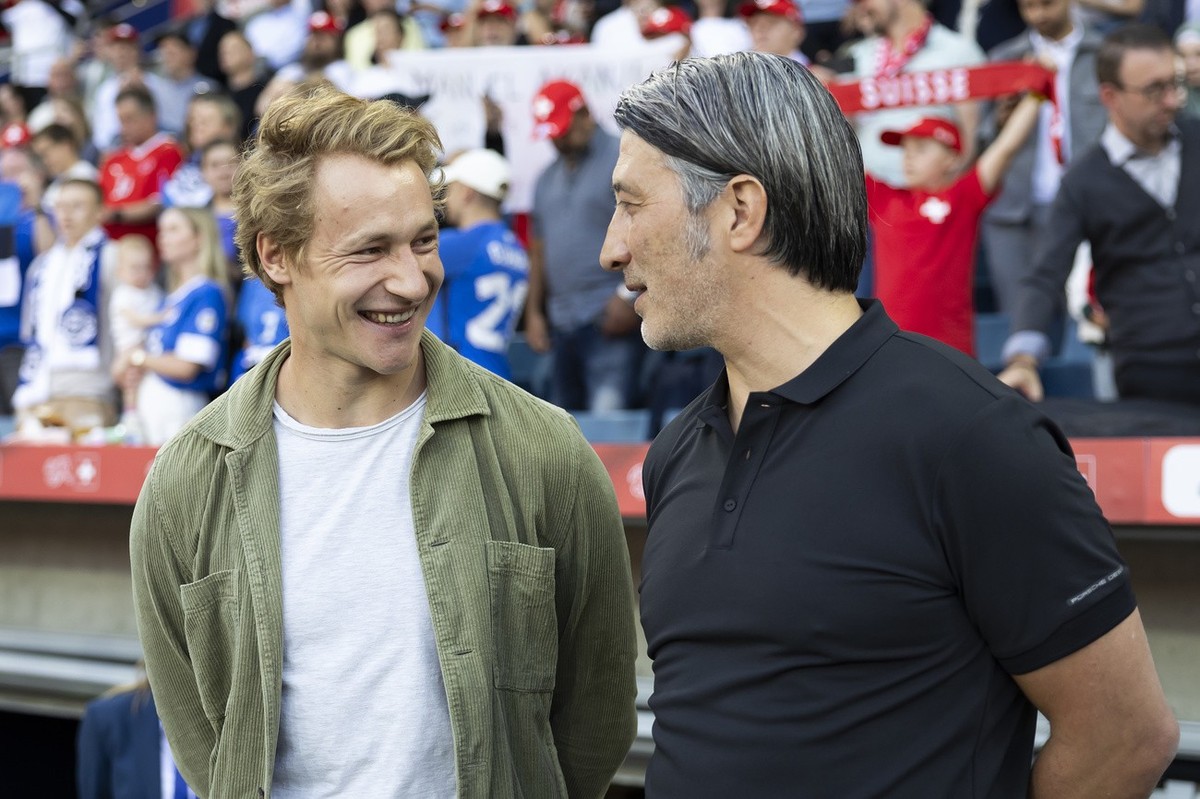 Switzerland's head coach Murat Yakin, right, and Swiss ski racer Marco Odermatt talk prior to an international friendly soccer match between Switzerland and Estonia at the Swissporarena in Lucern ...