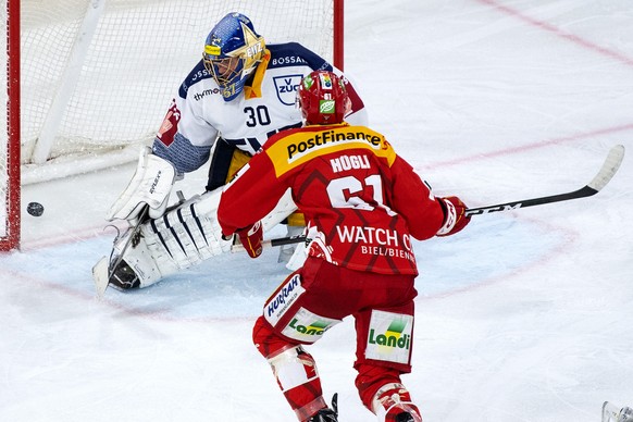 Biels Michael Huegli, hinten, trifft gegen Zugs Torhueter Leonardo Genoni zum 3-2 im Eishockey Meisterschaftsspiel der National League zwischen dem EHC Biel und dem EV Zug, am Samstag, 2. Oktober 2021 ...