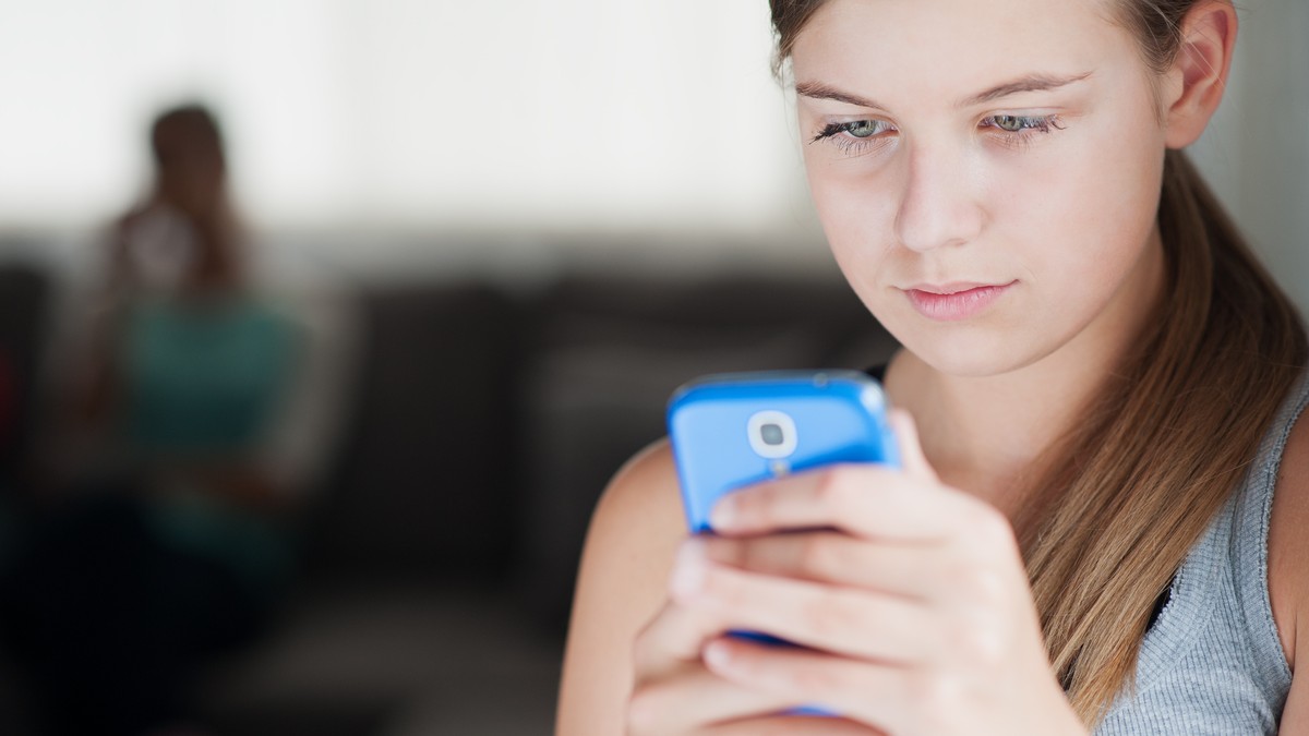 Teenager mit Mobilgerät (Handy, iPad)