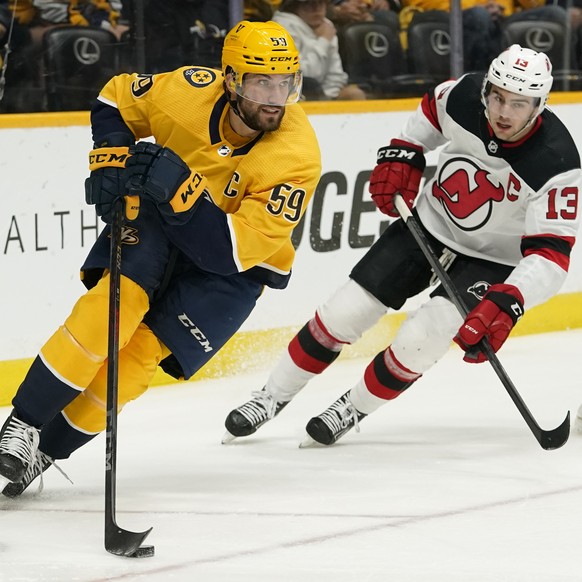 Nashville Predators defenseman Roman Josi (59) moves the puck ahead of New Jersey Devils center Nico Hischier (13) in the first period of an NHL hockey game Friday, Nov. 26, 2021, in Nashville, Tenn.  ...