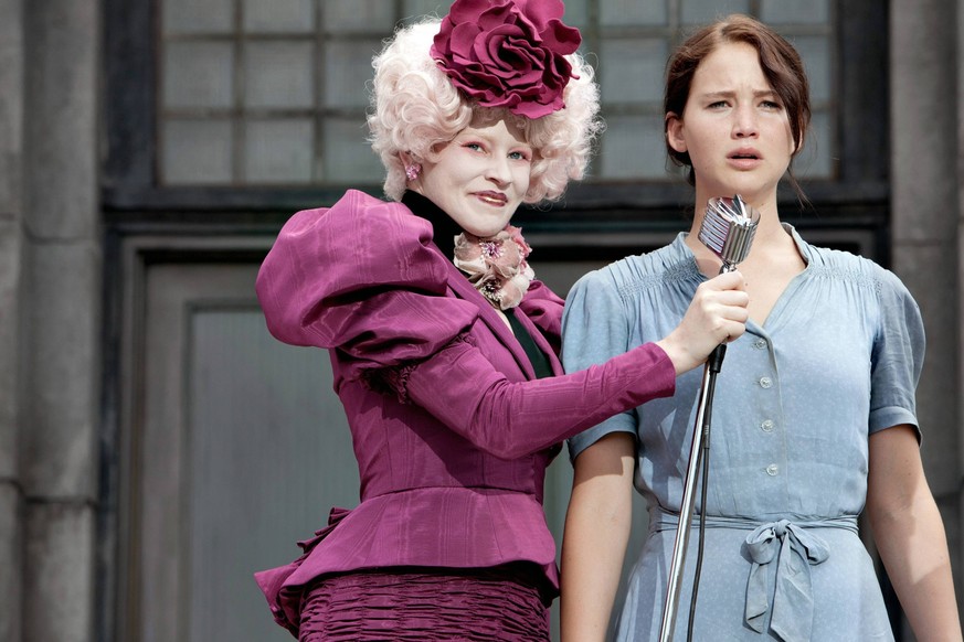 Effie Trinket (Elizabeth Banks, left) and Katniss Everdeen (Jennifer Lawrence) in THE HUNGER GAMES.  PUBLICATIONxINxGERxSUIxAUTxONLY Copyright: xPhotoxcredit:xMurrayxClosex 31361_011 Effie drinks E...
