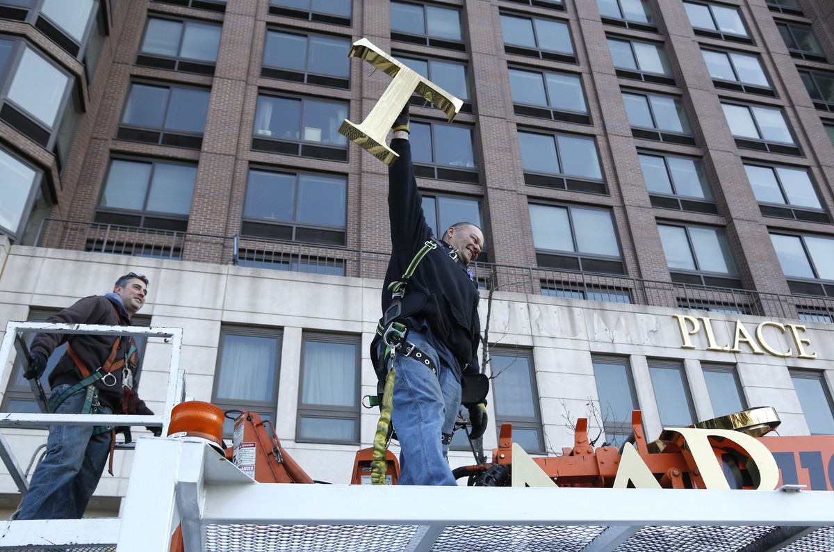 A workman holds up the letter "T" as they remove the letters from a building formerly known as Trump Place in New York, Wednesday, Nov. 16, 2016. Donald Trump's name is being stripped o ...