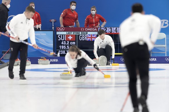 Martin Rios, center left, and Jenny Perret, center right, of Switzerland team, observe practice of Great Britain prior curling mixed doubles preliminary round game between Switzerland and Great Britai ...