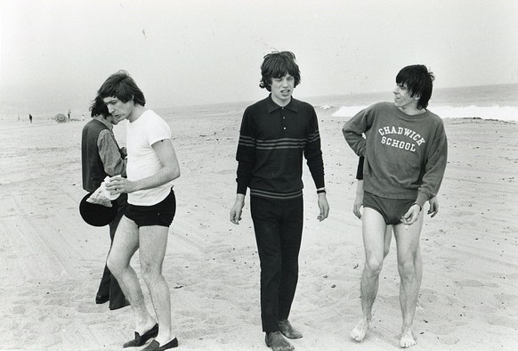 Members of the British rock group the Rolling Stones walk together on the beach, West Wittering, England, mid to late 1960s, Among those pictured are, from left, Charlie Watts, Mick Jagger, and Keith  ...
