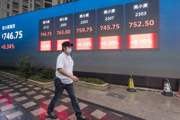 epa09510808 A man walks in front of the screen showing newest stock exchange and economic data in Shanghai, China, 07 October 2021. A debt crisis and rising bond yields of China Evergrande Group made  ...