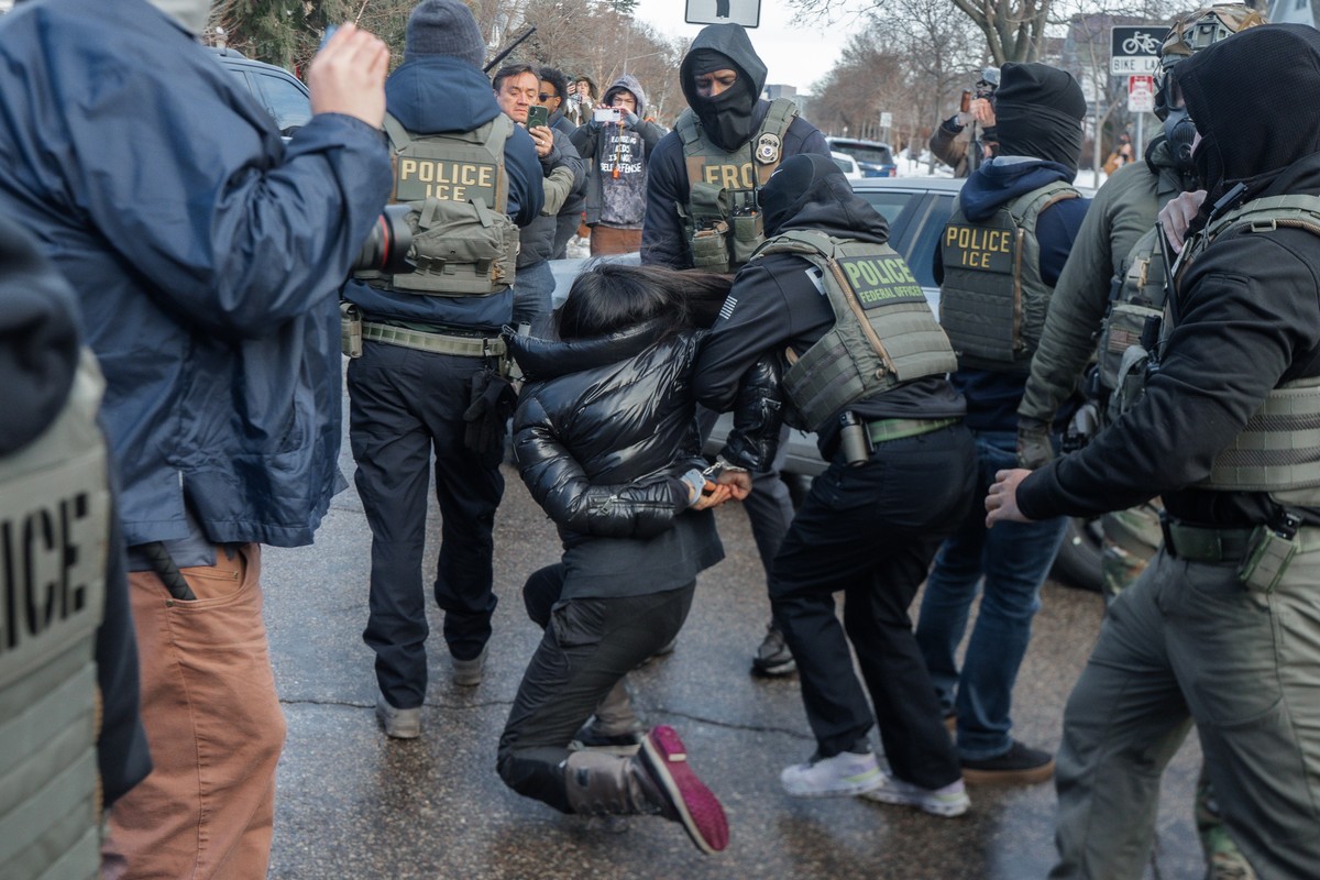 epa12647222 A woman stumbles and falls as federal immigration enforcement drag her after smashing the windows of her car in Minneapolis, Minnesota, USA, 13 January 2026. As part of a federal immigrati ...