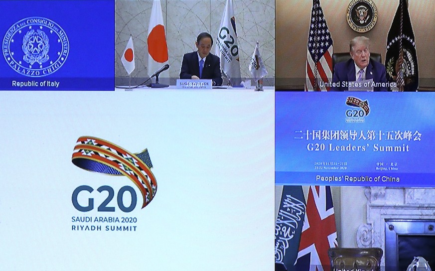 epa08832944 Japan's Prime Minister Yoshihide Suga and U.S. President Donald Trump are seen on a screen before the start of the virtual G20 meeting hosted by Saudi Arabia, amid the coronavirus disease  ...