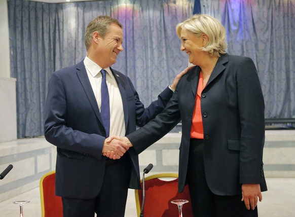 New campaign ally Nicolas Dupont-Aignan, left, and far-right candidate for the 2017 French presidential election Marine Le Pen shake hand as they arrived for a media conference in Paris, France, Satur ...