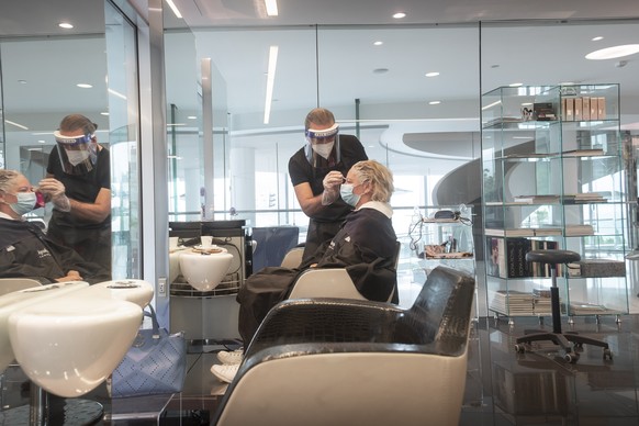 Ein Coiffeur faerbt einer Kundin die Haare, am Montag, 27. April 2020, in einem Coiffeursalon in Lugano. Coiffeure duerfen ihre Geschaefte ab heute wieder oeffnen. (KEYSTONE/Ti-Press/Pablo Gianinazzi)