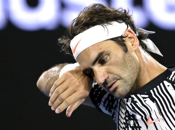 Switzerland&#039;s Roger Federer wipes the sweat from his face during his first round match against Austria&#039;s Jurgen Melzer at the Australian Open tennis championships in Melbourne, Australia, Mo ...