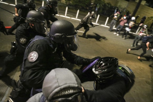 Police respond to protesters during a demonstration, Friday, July 17, 2020 in Portland, Ore. Militarized federal agents deployed by the president to Portland, Oregon, fired tear gas against protesters ...