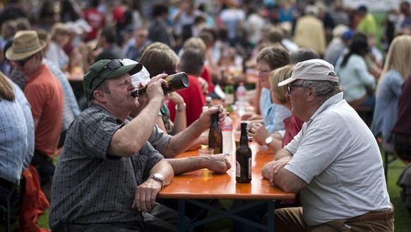Besucher trinken Bier und verweilen auf den Festbaenken am 92. Schwyzer Kantonal-Schwingfest, am Sonntag, 26. April 2015, in Kuessnacht am Rigi. (KEYSTONE/Ennio Leanza)