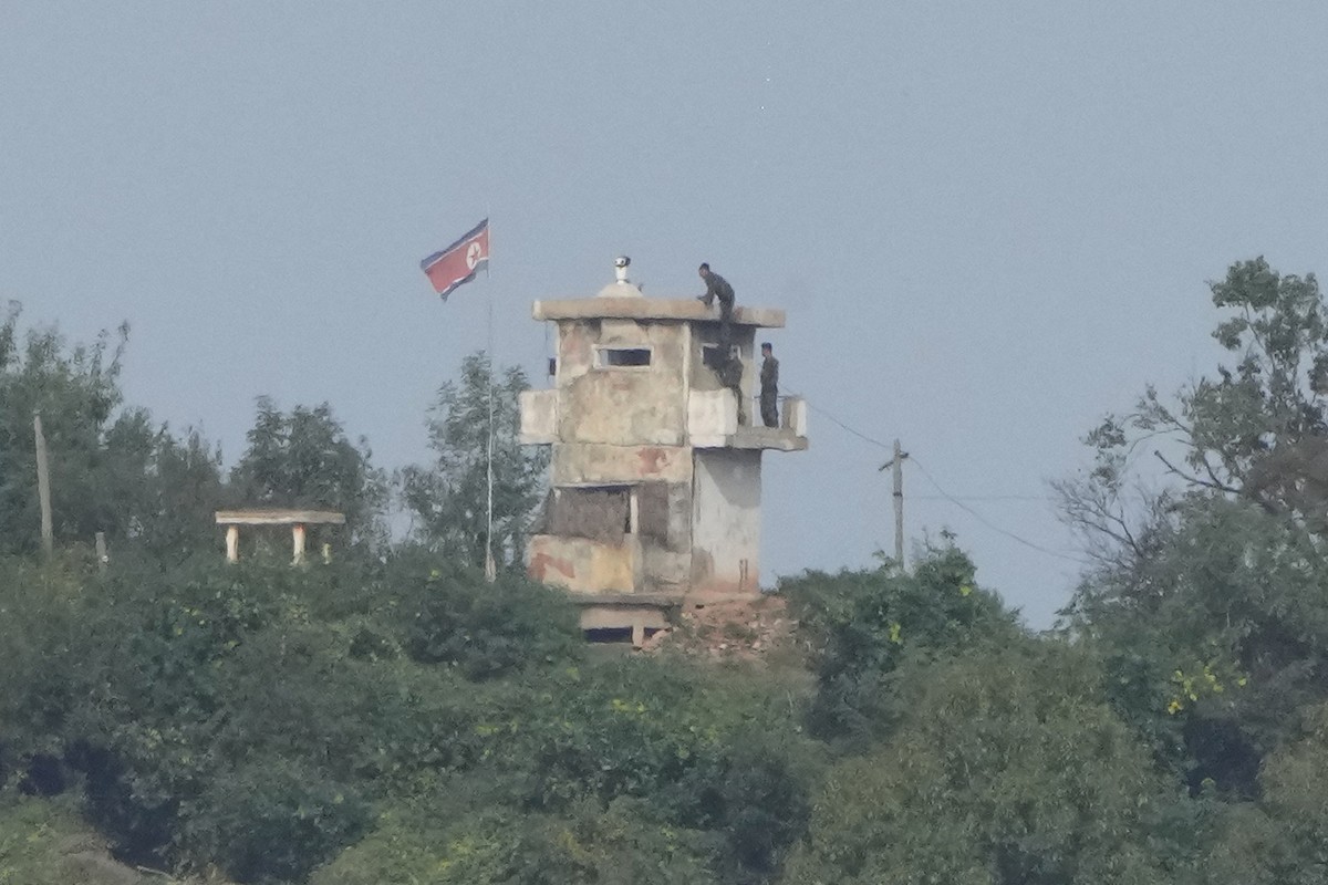 FILE - North Korean soldiers work at the North's military guard post as a North Korean flag flutters in the wind, are seen from Paju, South Korea, near the border with North Korea, Thursday, Oct. ...