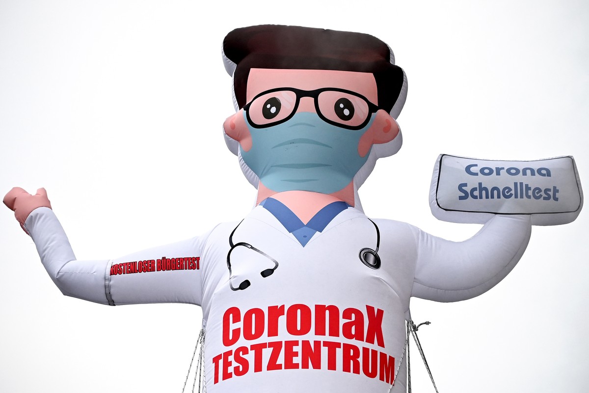 epa09708619 An inflatable airdancer doll points out a test station for coronavirus rapid tests, in Duesseldorf, Germany,25 January 2022. Certain groups of people in Germany will soon be prioritized fo ...