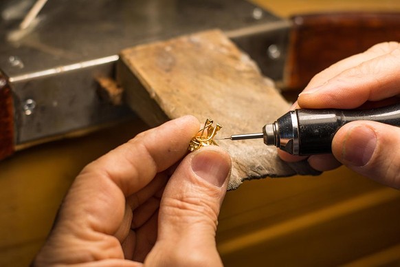 Hands of a craftsman jeweler working on jewelry. Goldsmith.
