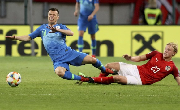 Slovenia&#039;s Damjan Bohar fights for the ball with Austria&#039;s Xaver Schlager, from left, during the Euro 2020 group G qualifying soccer match between Austria and Slovenia at Woerthersee stadium ...