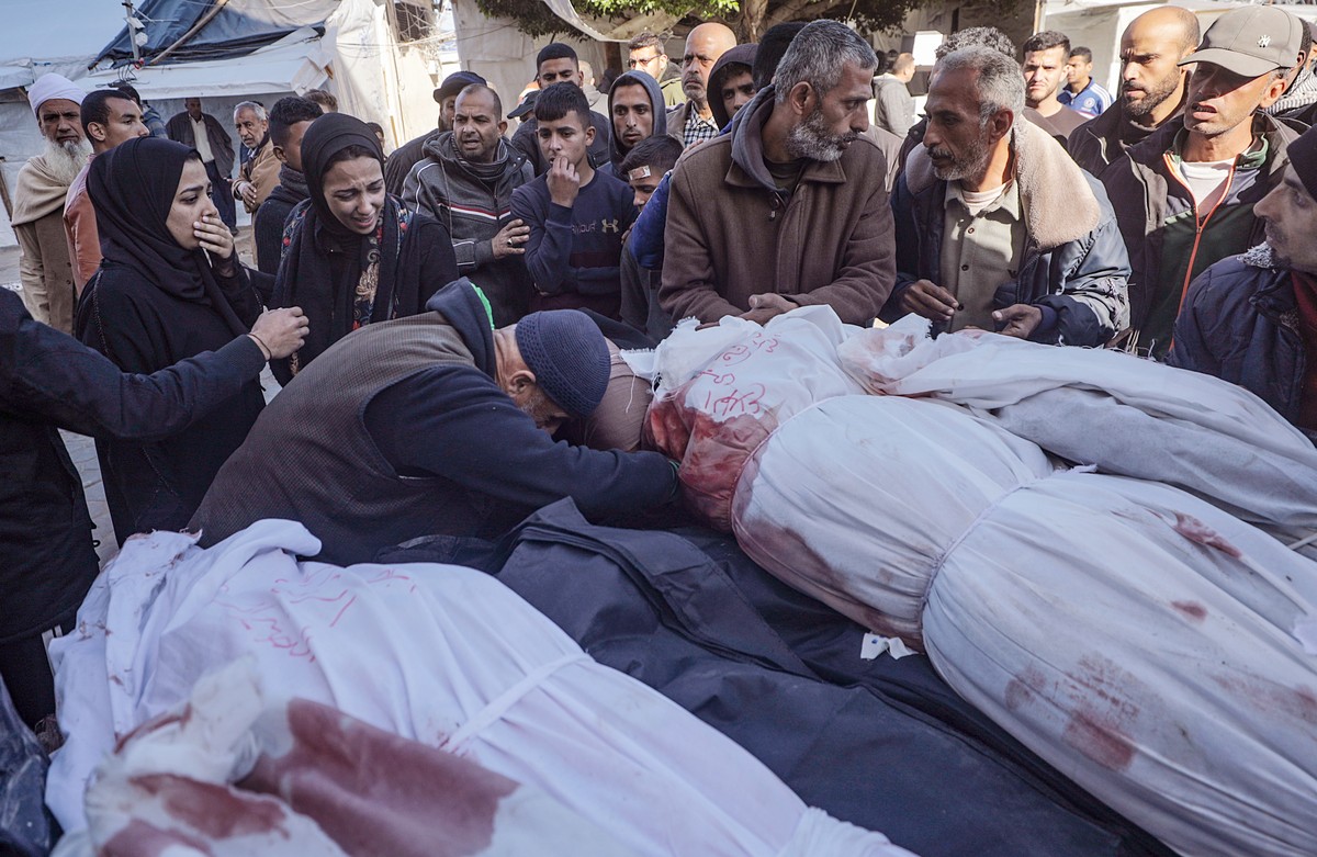 epa11230571 Relatives mourn over covered bodies following an Israeli air strike in Al Nusairat refugee camp, Gaza Strip, 20 March 2024. According to the Palestinian Ministry of Health, a strike on a r ...