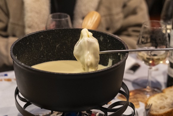 epa12528439 Visitors taste fondue during the 5th edition of the 'Mondial de fondue' in Tartegnin, Switzerland 15 November 2025. The 'Mondial de fondue' is held every two years in t ...