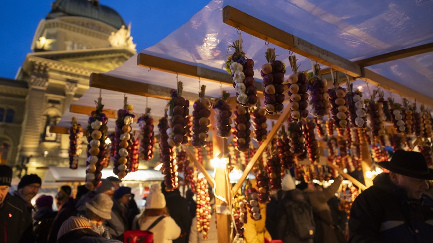 Zwiebeln haengen an einem Verkaufsstand vor dem Bundeshaus waehrend dem traditionellen "Zibelemaerit", am Montag, 27. November 2023 in Bern. Der Zibelemaerit findet am vierten Montag im Nove ...