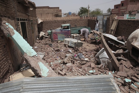 FILE - A man clears the rubble of a house hit during recent fighting in Khartoum, Sudan, Tuesday, April 25, 2023. Khartoum, a city of some 5 million people, has been transformed into a frontline in the rut…