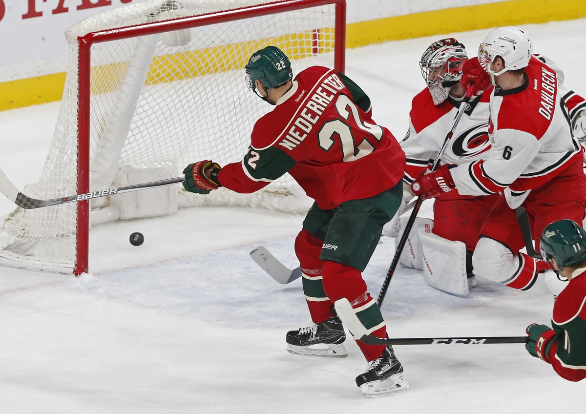 Minnesota Wild's Nino Niederreiter, left, of Switzerland, scores against Carolina Hurricanes goalie Cam Ward, right, in the first period of an NHL hockey game Tuesday, April 4, 2017, in St. Paul, ...