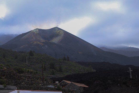 epa09835662 A general view of the Cumbre Vieja volcano and a river of solidified lava (R), six months after its eruption in La Palma island, Canary Islands, southwestern Spain, 19 March 2022. Six mont ...