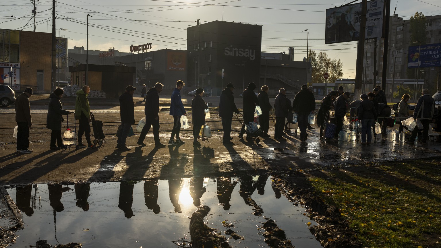 TILE - People queuing hold plastic bottles to refill drinking water from a tank in the center of Mykolaiv, Monday, Oct. 1.  24, 2022. As milestones go, the first anniversary of the Russian invasion of…
