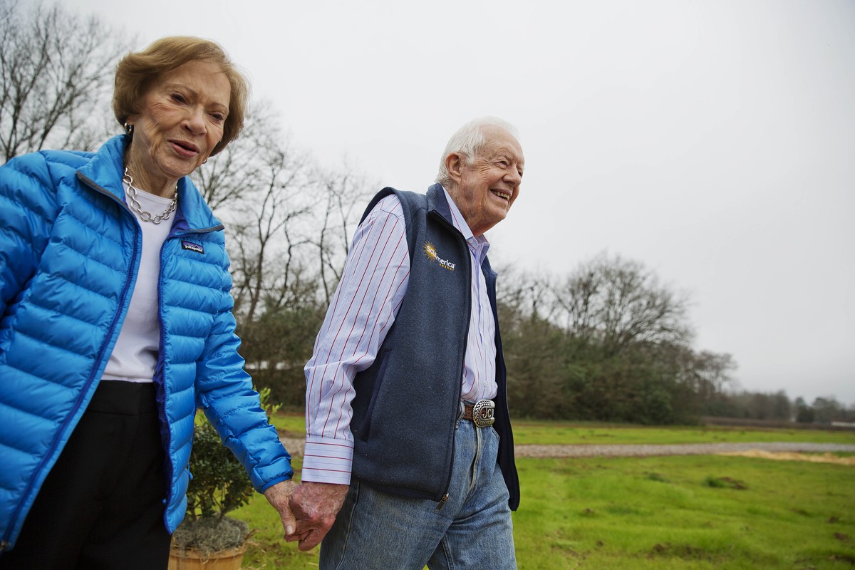 FILE - Former President Jimmy Carter, right, and his wife, former first lady Rosalynn Carter, arrive for a ribbon cutting ceremony for a solar panel project on farmland he owns in their hometown of Pl ...