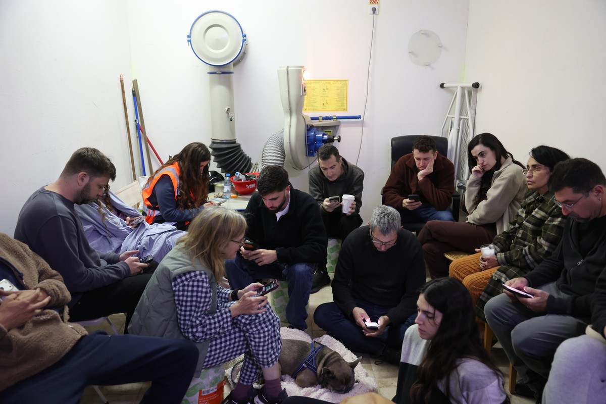 epa12786359 People sit in a shelter in Tel Aviv, Israel, 01 March 2026. The Israeli military reported on 28 February it detected missiles launched from Iran following earlier Israeli and US strikes on ...