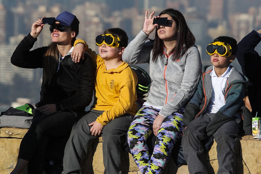 epa07690735 People watch the full solar eclipse from the San Cristobal mountain, in Santiago, Chile, 02 July 2019. A total solar eclipse will cross above Chile and Argentina, as well as the waters of  ...