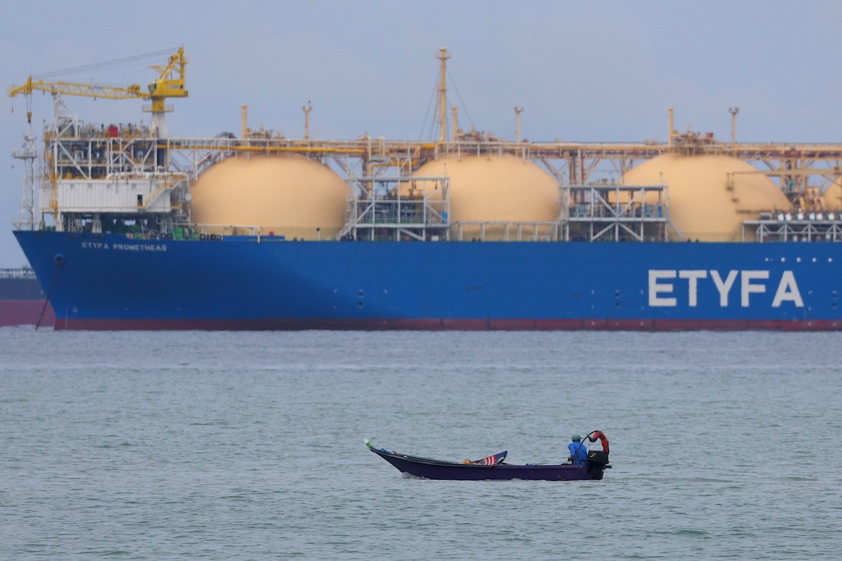 epa12048631 A fisherman passes by the liquefied natural gas (LNG) tanker ETYFA-Prometheas at the Malacca Strait in Malaysia, 23 April 2025. EPA/FAZRY ISMAIL