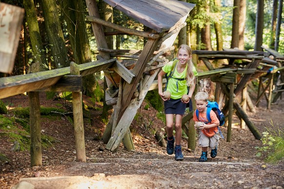 Familie im Zyberliland Romoos. Immer wieder machen die Bärgmandli mit kleinen roten Füsschen auf sich aufmerksam und führen die neugierigen Kinder durch die malerische Natur zu den sechs verschiedenen ...