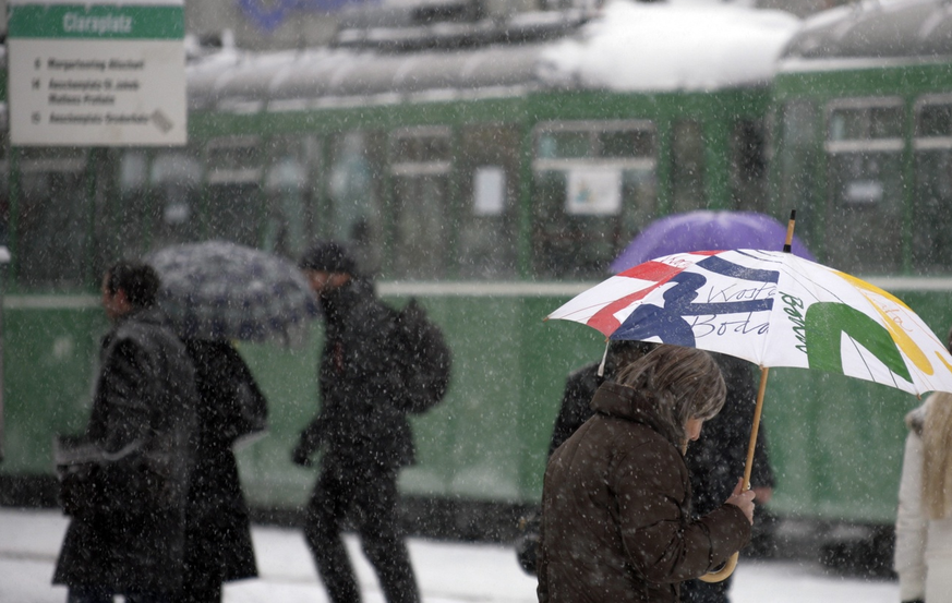 Passanten gehen auf dem Claraplatz in Basel durch das Schneegestoeber, am Mittwoch, 24. Januar 2007.