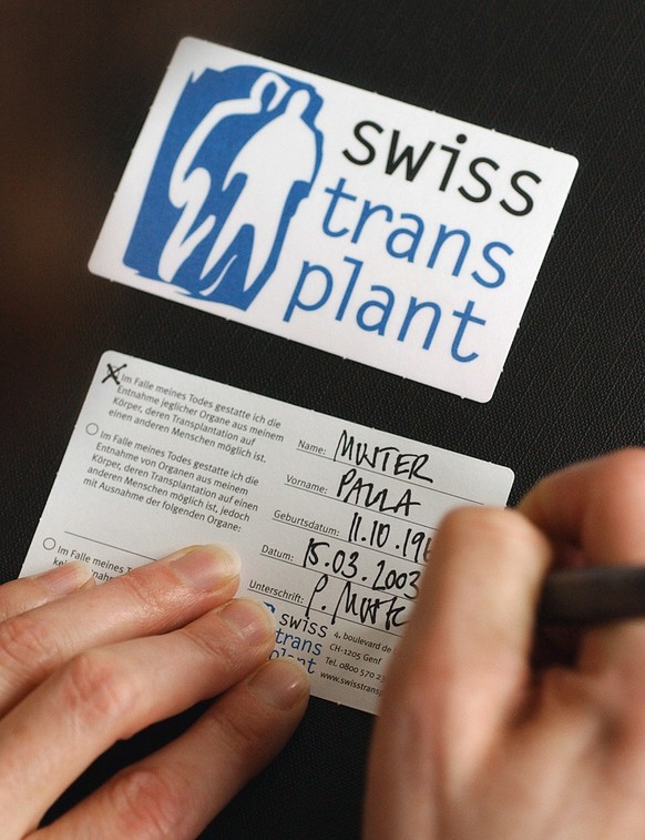 Eine Frau fuellt am 15. Dezember 2003 eine Organspende Karte von Swisstransplant in Zuerich aus. (KEYSTONE/Gaetan Bally)