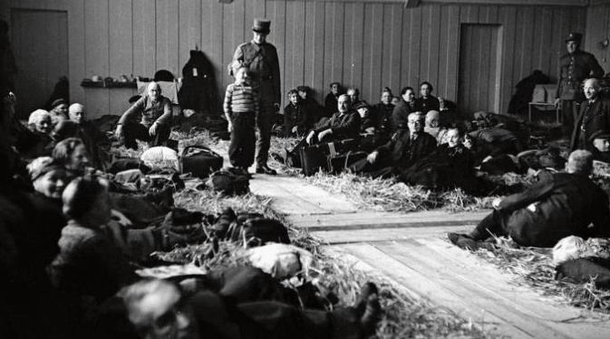 Robert Narev (Bildmitte) mit einem Soldaten nach der Ankunft im Hadwig-Schulhaus im Februar 1945. Die Turnhalle wurde damals als Strohlager für jüdische Flüchtlinge hergerichtet.