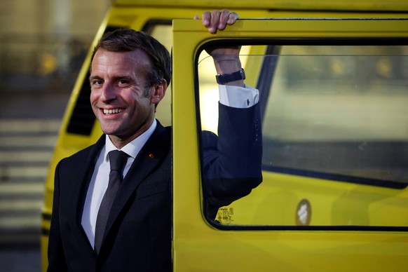 epa09498515 French President Emmanuel Macron poses in front of a danfo bus from Nigeria in the courtyard of the Elysee Palace, prior to host a dinner as part of the closing ceremony of the Africa2020  ...