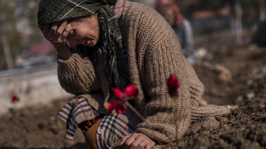 A member of the Vehibe family mourns a relative during the burial of one of the earthquake victims that struck a border region of Turkey and Syria five days ago in Antakya, southeastern Turkey, on Sat ...