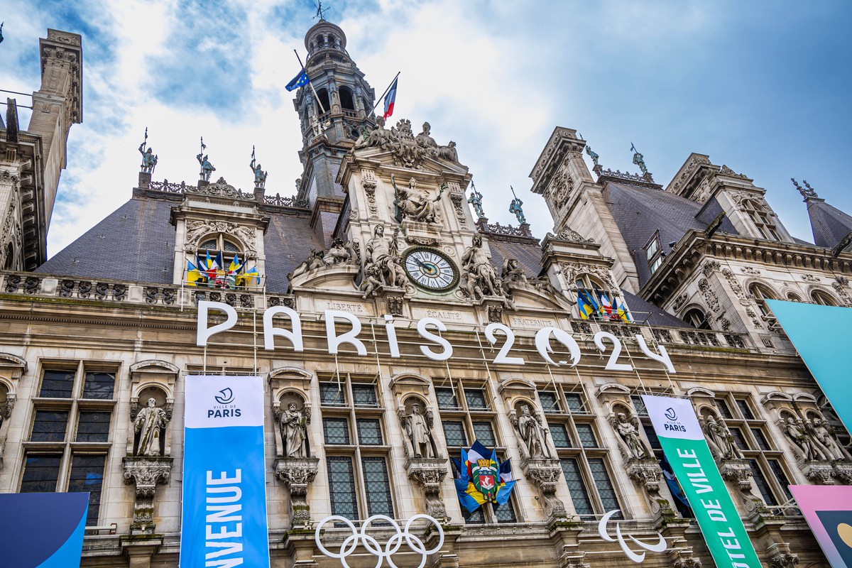 epa11240875 The facade of Paris City Hall decorated with the Olympic rings before the Waiters' race (Course des Cafes), in Paris, France, 24 March 2024. Some 200 waiters are taking part in the tr ...