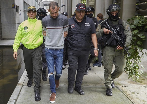 In this handout photo released by Colombia&#039;s Attorney General Press Office, police escort Wendre Still Scott Carrillo after being captured in Medellin, Colombia, Friday, June 3, 2022. Wendre Stil ...