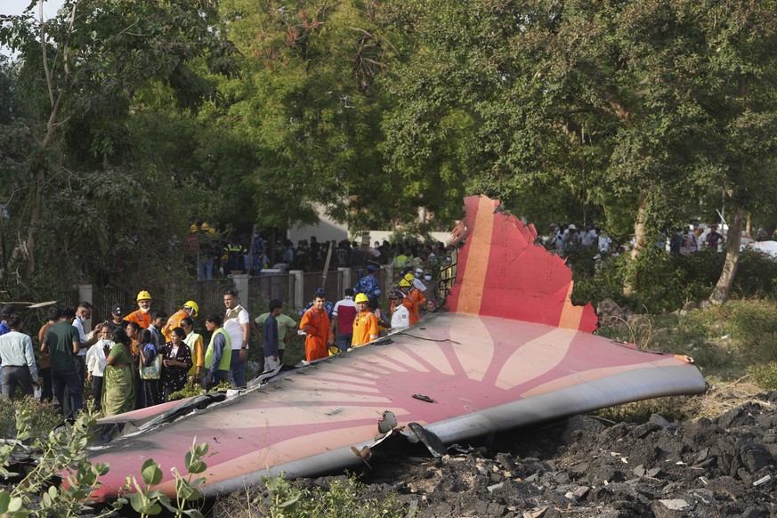 People stand around the debris of an airplane after it crashed in India&#039;s northwestern city of Ahmedabad in Gujarat state, Thursday, June 12, 2025. (AP Photo/Ajit Solanki)
APTOPIX India Plane Cra ...