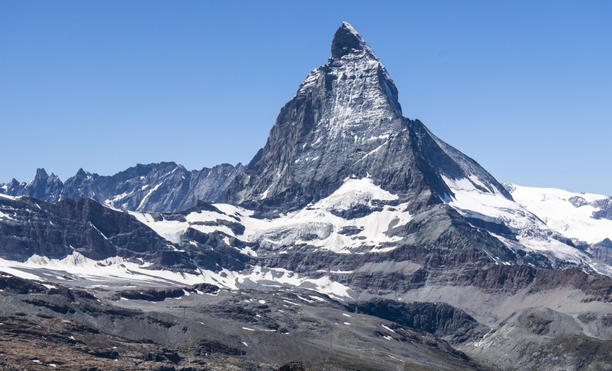 Des touristes marchent dans la montagne depuis le Gornergrat en face du Cervin a cote du train du chemin de fer du Gornergrat pendant la crise du Coronavirus (Covid-19) a l'occasion des vacances  ...