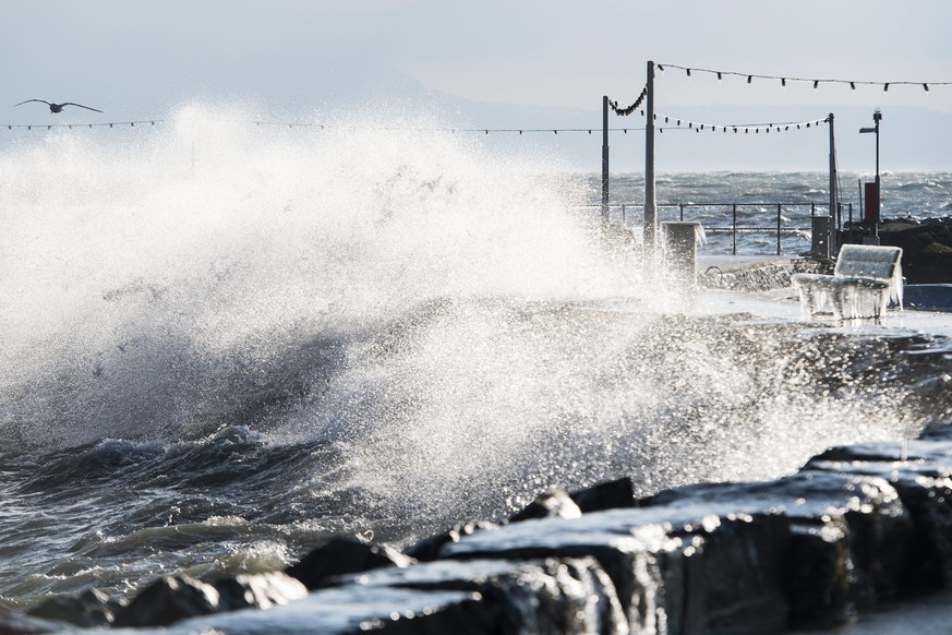 epa05724899 Waves crash next to a bench covered in ice after the strong wind at Lake Leman in Versoix, Geneva, Switzerland, 17 January 2017. EPA/JEAN-CHRISTOPHE BOTT