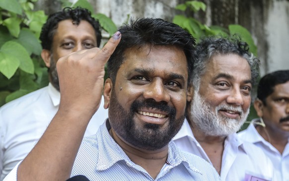 epa11617016 Anura Kumara Dissanayake, presidential candidate and leader of the opposition party National People&#039;s Power (NPP), shows his ink-marked finger after casting his vote during the presid ...