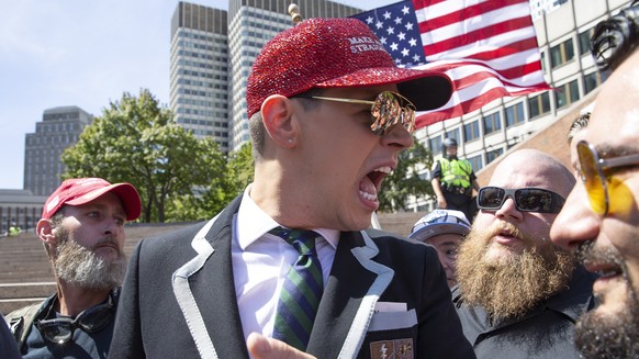 epa07808436 Milo Yiannopoulos (C) is flanked by security as he takes part in the 'Straight Pride Parade' in Boston, Massachusetts, USA, 31 August 2019. Despite outrage from local politicians ...