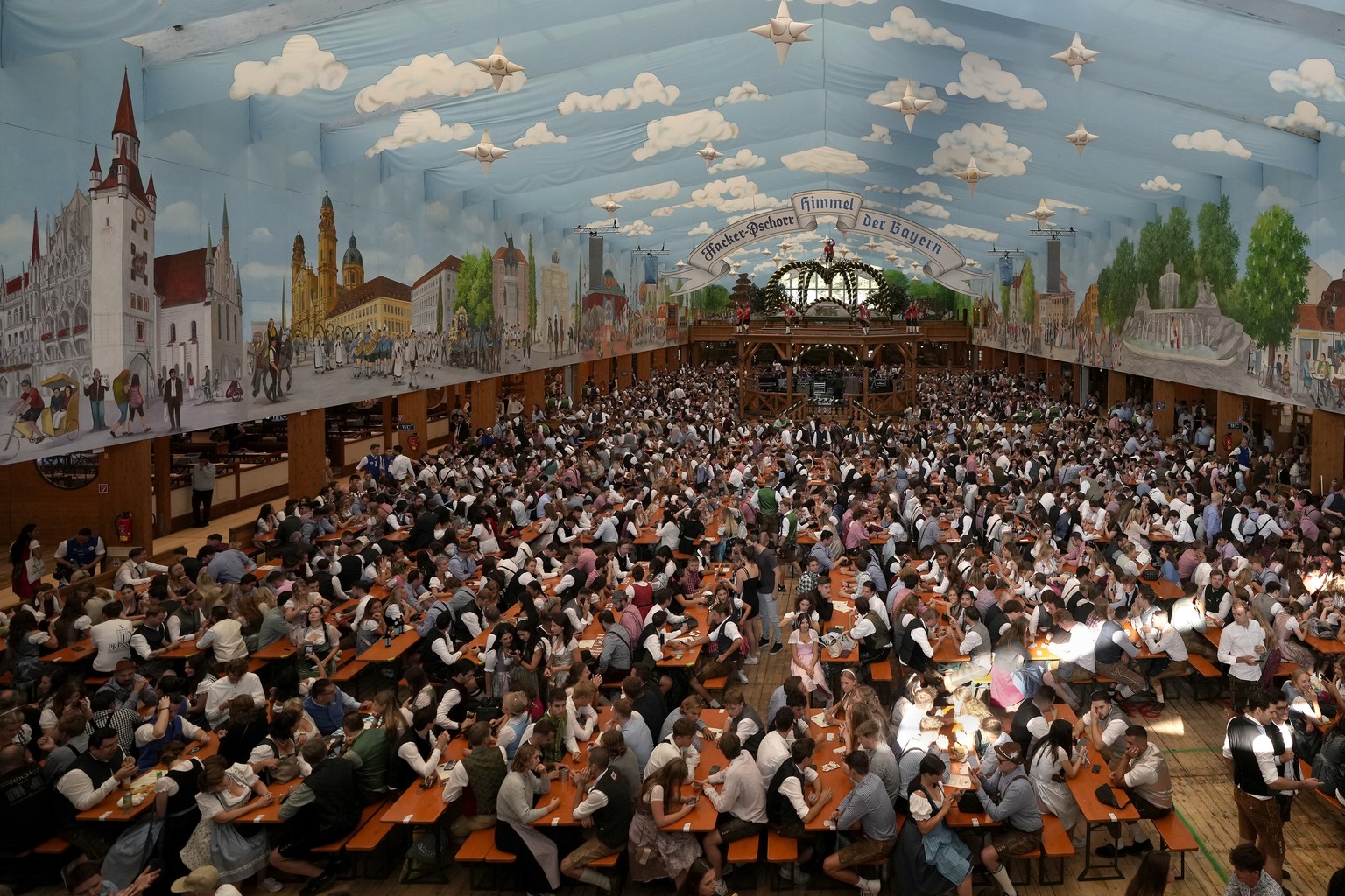 People sit in a marquee shortly after the opening of the 188th 'Oktoberfest' beer festival in Munich, Germany, Saturday, September 16, 2023. (AP Photo/Matthias Schrader)