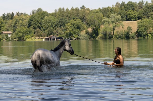 Shannon und ihr Pferd kuehlen sich im Wasser am Katzensee ab, am Freitag, 27. Juli 2018, in Zuerich. (KEYSTONE/Melanie Duchene)