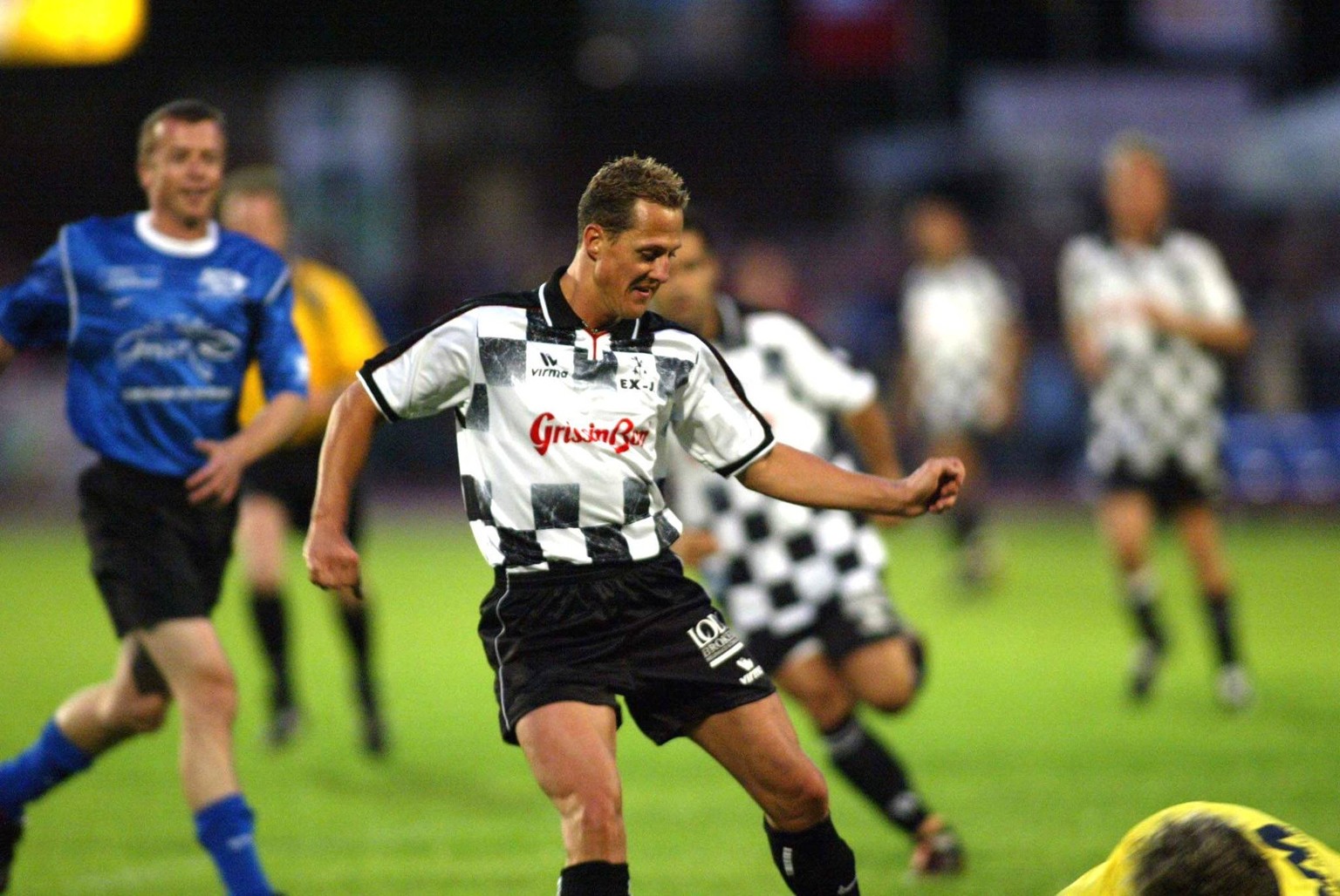 BRU135 - - VERVIERS, BELGIUM: Formula One pilot Michael Schumacher chases the ball during a soccer match for the benefit of children defence association Child Focus, Wednesday 25 August 2004 in Vervie ...
